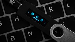 A Ledger Nano hardware wallet seen on a keyboard.